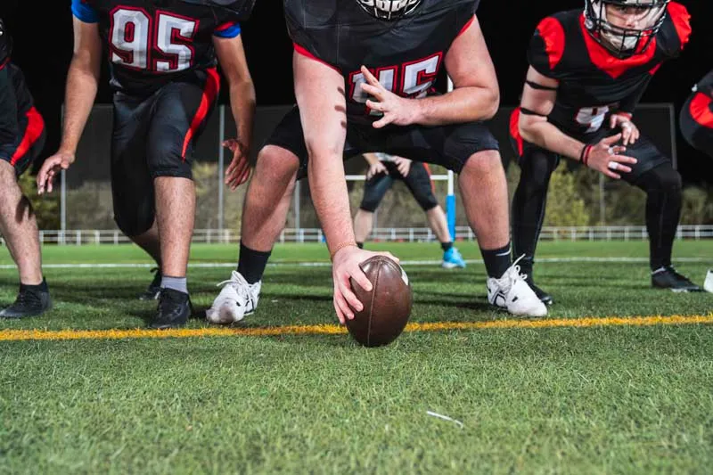 American football players preparing for a play on the field