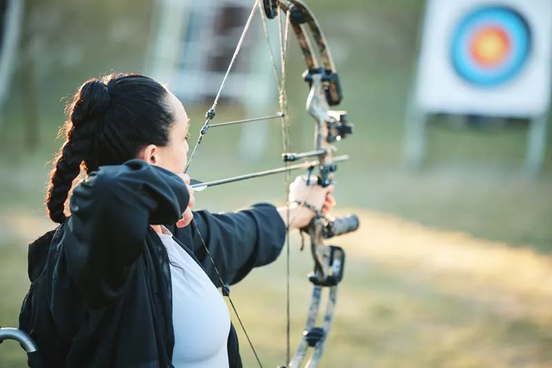 Woman practising archery outdoors