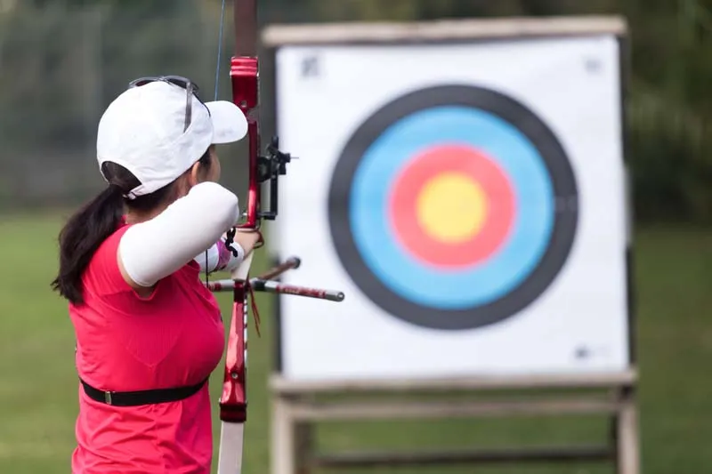 Female athlete practising archery in a stadium