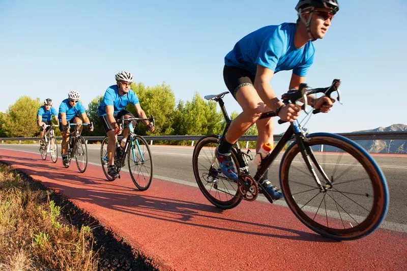 Cyclists riding bicycles on a red cycle lane