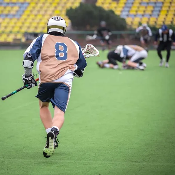 Lacrosse player dodging and controlling the ball on the field