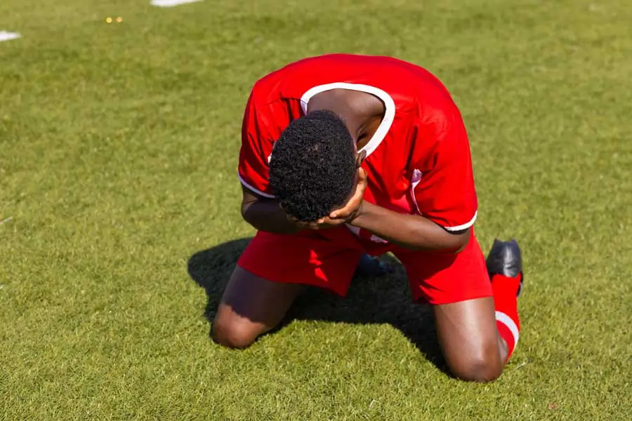african american soccer player kneeling on grass f 2025 04 05 08 05 37 utc