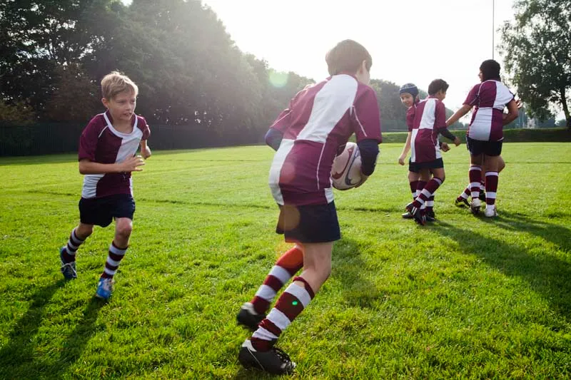 Boys playing rugby outdoors