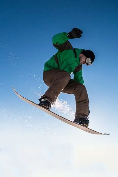 Snowboarder jumping high with style on slopes