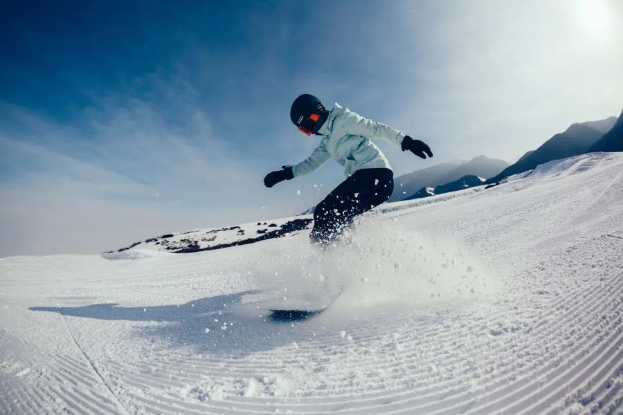 Female snowboarder descent on winter mountain slope